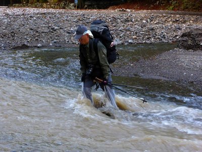 茶屋川の濁流を渡渉するクロオさん（茨川で）