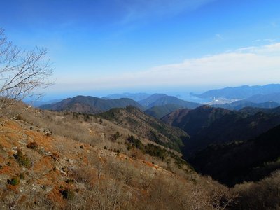 尾根が合流する１２１０m稜線（龍辻）から望む尾鷲市街。<br />山腹は樹木が少ない。