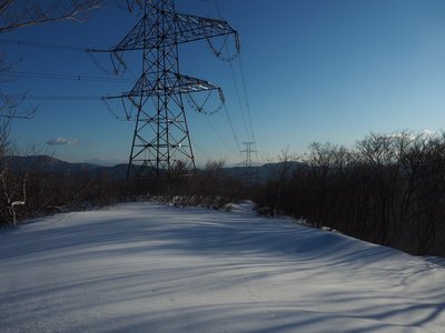 鉄塔尾根に西陽がおとす黄金色の光と蒼いシルエット