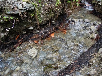 マナコ谷乾溜工場跡<br />黒い炭（焼けた土？）と土管が現れた。